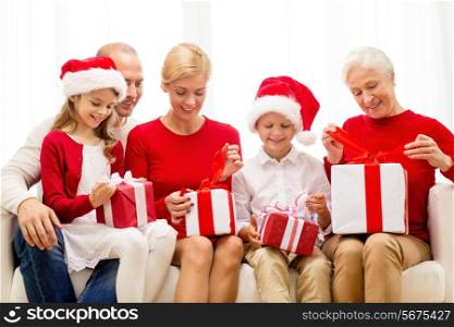 family, holidays, generation, christmas and people concept - smiling family opening gift boxes at home