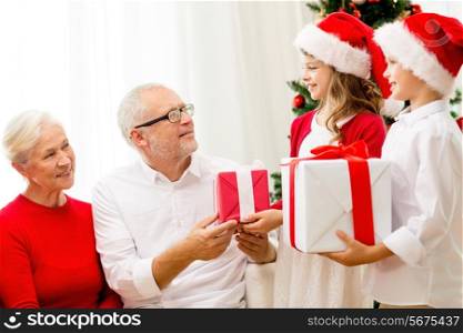 family, holidays, generation, christmas and people concept - smiling family with gift boxes at home