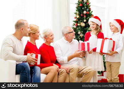 family, holidays, generation, christmas and people concept - smiling family with gift boxes at home