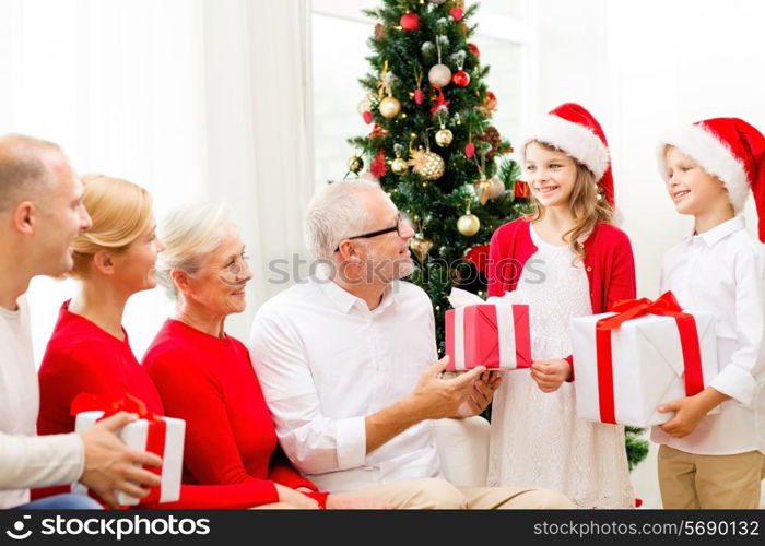 family, holidays, generation, christmas and people concept - smiling family with gift boxes at home