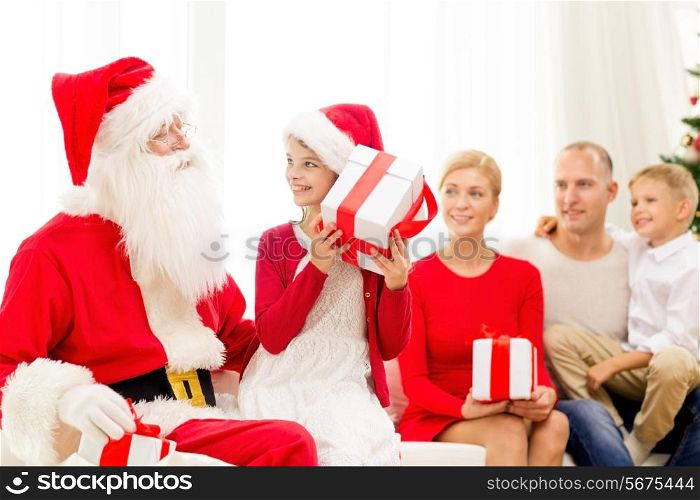 family, holidays, generation, christmas and people concept - smiling family with santa claus and gift boxes at home