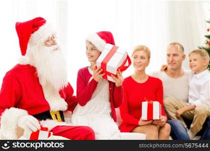 family, holidays, generation, christmas and people concept - smiling family with santa claus and gift boxes at home