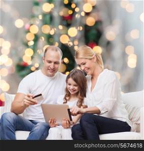 family, holidays, shopping, technology and people - smiling family with tablet pc computer and credit card over christmas tree lights background