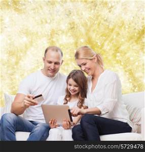 family, holidays, shopping, technology and people - smiling family with tablet pc computer and credit card over yellow lights background