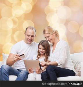 family, holidays, shopping, technology and people - smiling family with tablet pc computer and credit card over beige lights background
