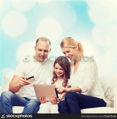 family, holidays, shopping, technology and people - smiling family with tablet pc computer and credit card over blue lights background