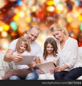 family, holidays, technology and people - smiling mother, father and little girls with tablet pc computers over red lights background