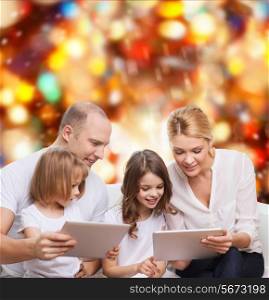 family, holidays, technology and people - smiling mother, father and little girls with tablet pc computers over red lights background