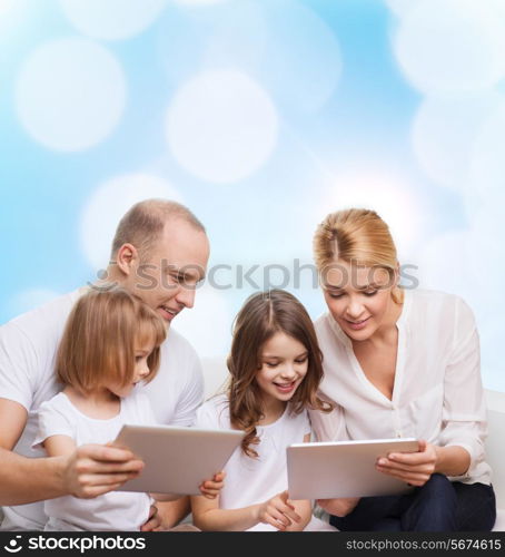 family, holidays, technology and people - smiling mother, father and little girls with tablet pc computers over blue lights background