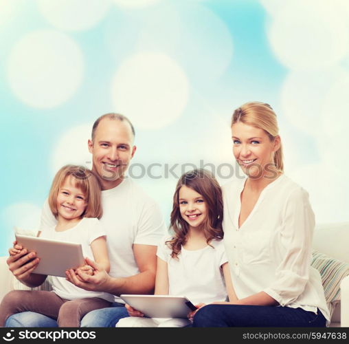 family, holidays, technology and people - smiling mother, father and little girls with tablet pc computers over blue lights background