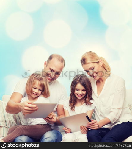 family, holidays, technology and people - smiling mother, father and little girls with tablet pc computers over blue lights background