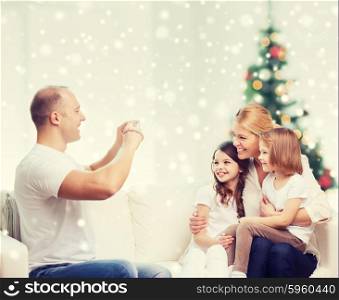 family, holidays, technology and people - smiling mother, father and little girls with camera photographing at home