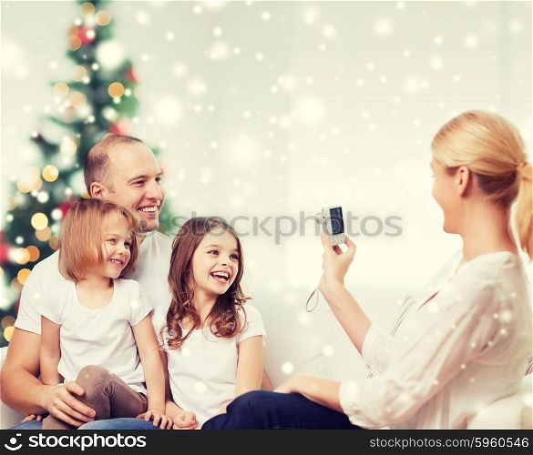 family, holidays, technology and people - smiling mother, father and little girls with camera photographing at home