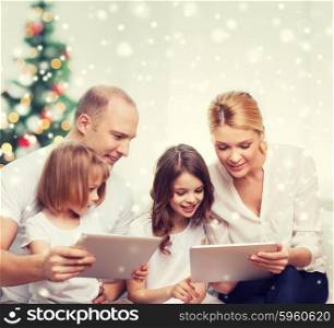 family, holidays, technology and people - smiling mother, father and little girls with tablet pc computers at home