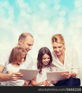 family, holidays, technology and people - smiling mother, father and little girls with tablet pc computers over blue lights background