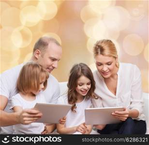 family, holidays, technology and people - smiling mother, father and little girls with tablet pc computers over beige lights background