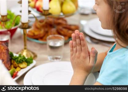 family, holidays, thanksgiving day and people concept - close up of girl having dinner and praying at home. close up of girl having dinner and praying at home
