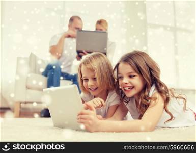 family, home, technology and people - smiling mother, father and little girls with tablet pc computer over snowflakes background