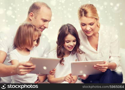 family, home, technology and people - smiling mother, father and little girls with tablet pc computers over snowflakes background