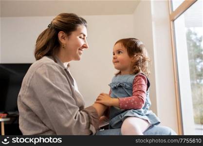 family, hygge and people concept - happy mother and little daughter playing at home. mother and daughter playing at home