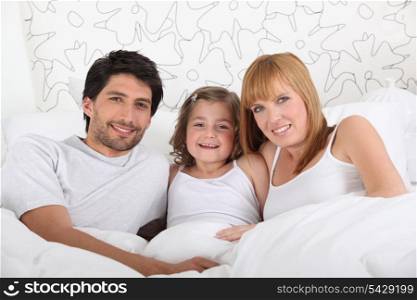 Family in bed together on Sunday morning