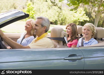 Family in convertible car smiling