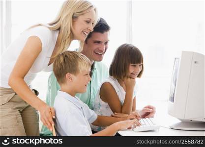 Family in home office using computer smiling