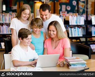Family in library with notebook. Family in library