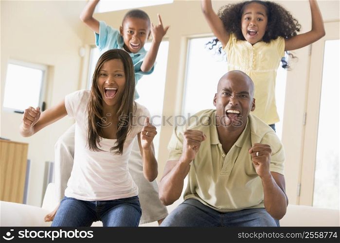 Family in living room cheering and smiling