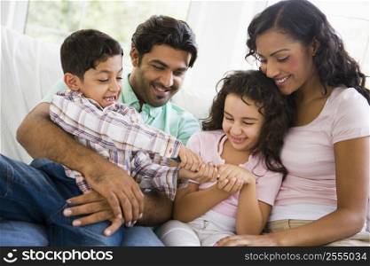 Family in living room fighting over remote control smiling (high key)