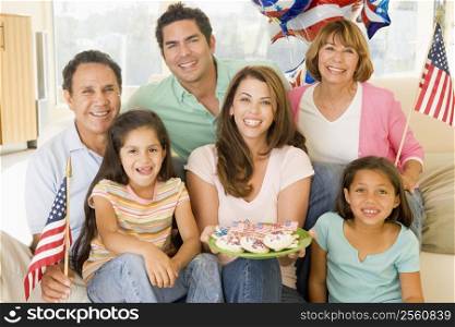 Family in living room on fourth of July with flags and cookies smiling