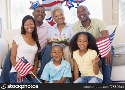Family in living room on fourth of July with flags and cookies smiling