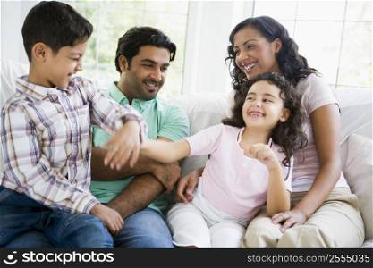 Family in living room play fighting and smiling (high key/selective focus)