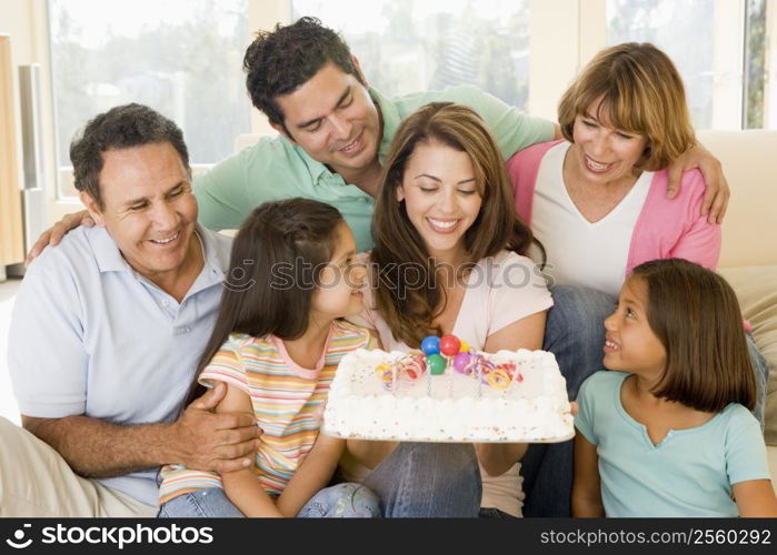 Family in living room with cake smiling