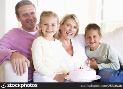 Family in living room with cake smiling