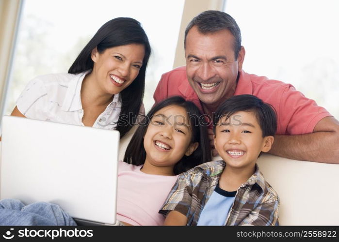 Family in living room with laptop smiling