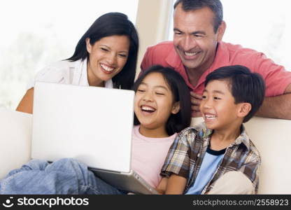 Family in living room with laptop smiling