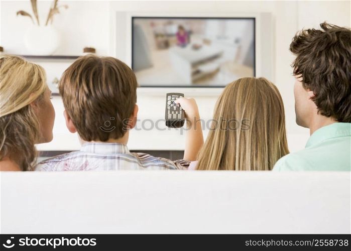 Family in living room with remote control and flat screen television