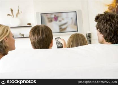 Family in living room with remote control and flat screen television