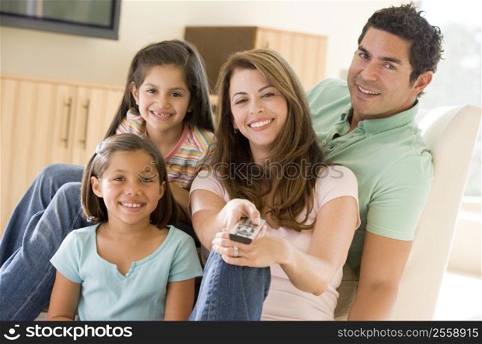 Family in living room with remote control smiling