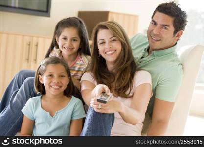 Family in living room with remote control smiling
