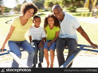 Family In Park Riding On Roundabout