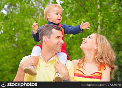 Family in park with child on shoulders