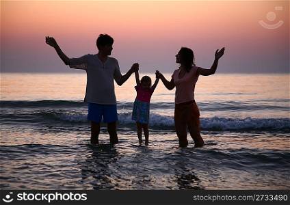 Family in sea on sunset
