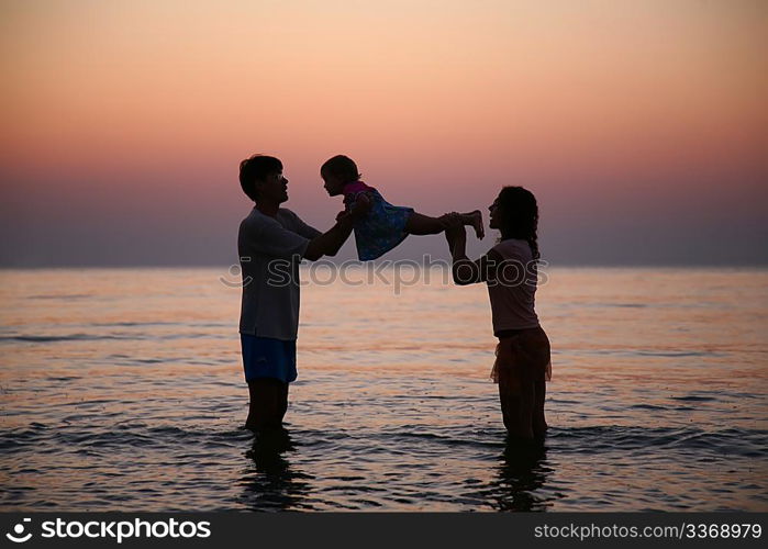 Family in sea on sunset