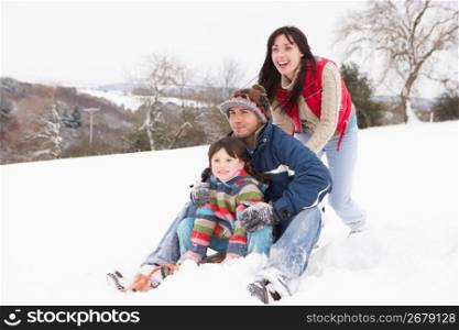Family In Snow Riding On Sledge