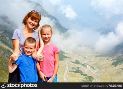 Family in summer mountain. View from Transfagarasan road (Romania)