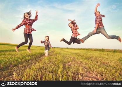 family jumping in the field