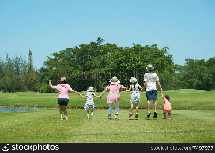Family jumping together hand in hand enjoy in the park