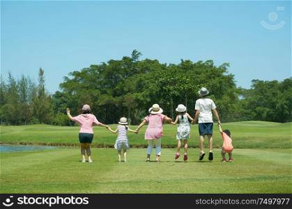 Family jumping together hand in hand enjoy in the park